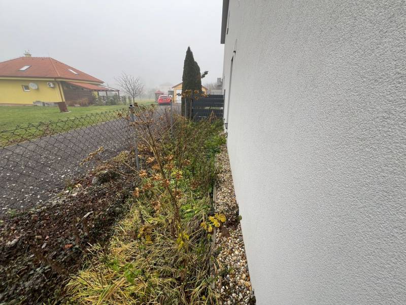 Cloudy weather in Plavecký Mikuláš at a family house with fencing and greenery.