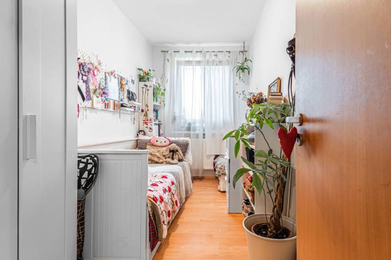 A children's room with light walls, decorations, and a wooden decor floor in a 4-room apartment.