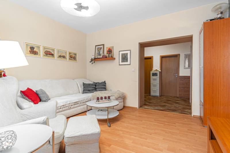 Living room with light-colored sofa seating and wood-patterned flooring in a 4-room apartment.