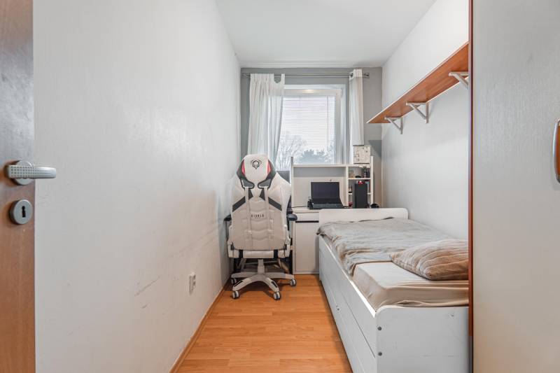 Room in a 4-room apartment with a bed, office chair, and desk.