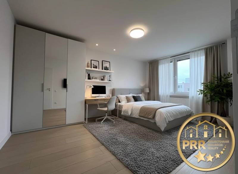 A bedroom in a 3-room apartment with a wooden decor floor and a desk.