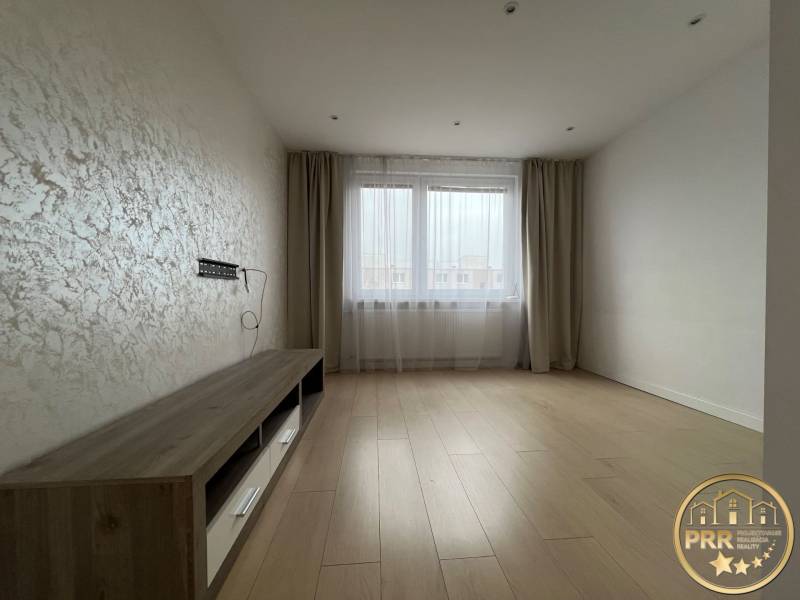 A room in a 3-room apartment with a floor featuring a wood decor and a window with curtains.