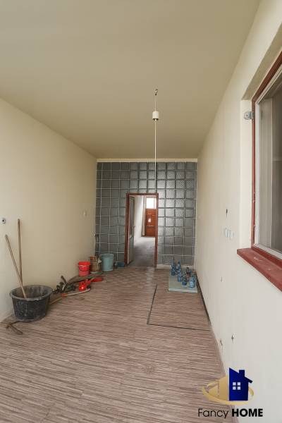 A hallway in a family house with a wooden decor floor and a glass wall.