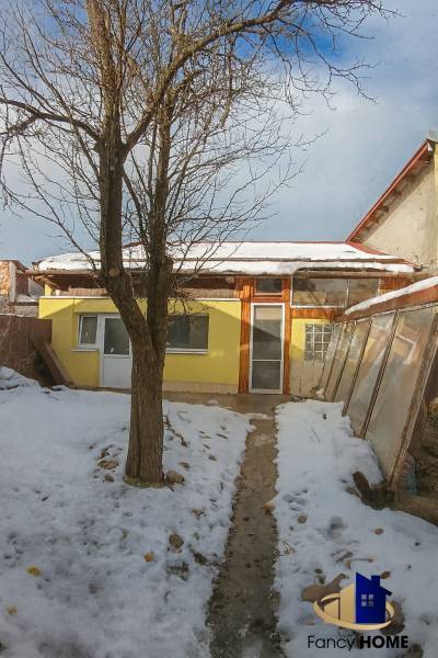 A family house on Garbiarska Street in Stará Ľubovňa with a snowy garden and a tree.