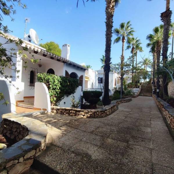 A family house in Orihuela Costa, Villa Martin, surrounded by palm trees, with a terrace and a garden.