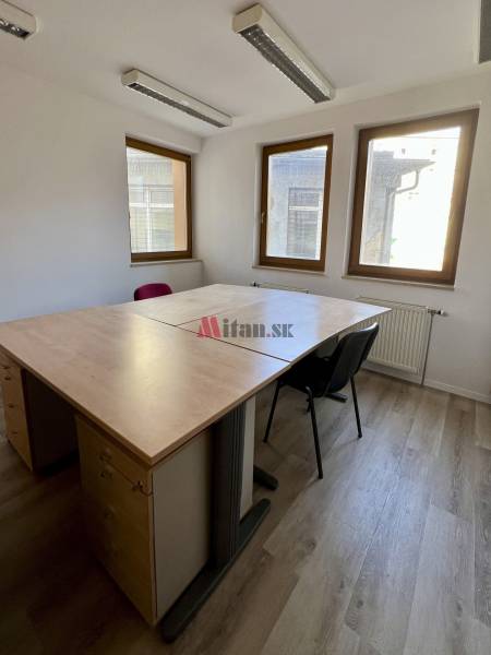Offices with wood-patterned flooring, a desk, and chairs.