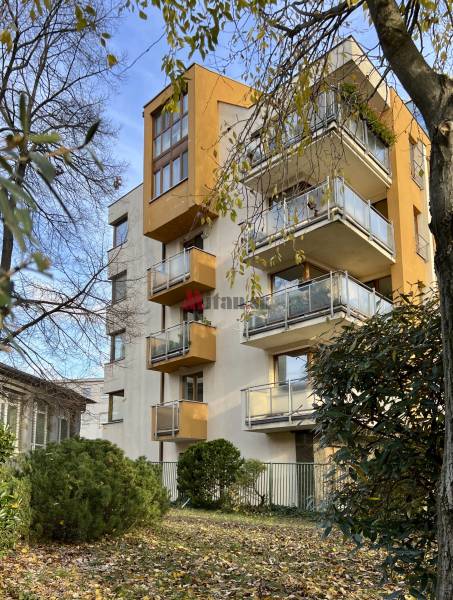 A building with balconies surrounded by trees and shrubs on Fazuľová Street in Bratislava - Old Town.