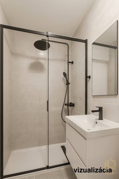 A shower corner with black accessories and a white sink in a 2-room apartment.