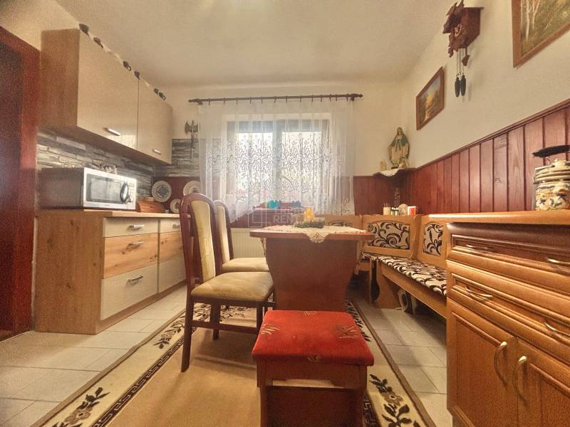 A kitchen in a family house with a corner bench, a microwave, and decorative elements.