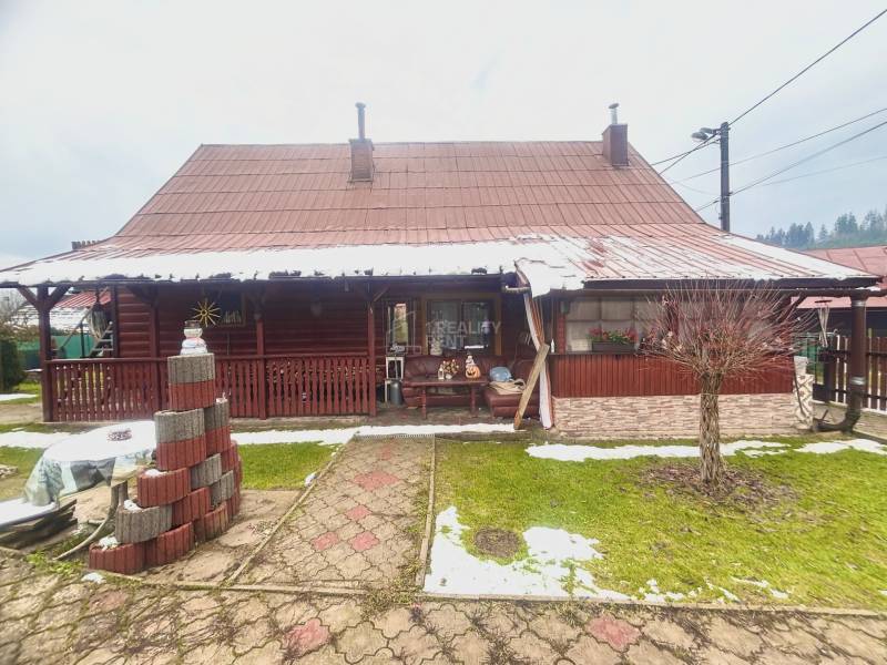 A family house in Predmier in Turzovka with wooden cladding and a snow-covered roof.