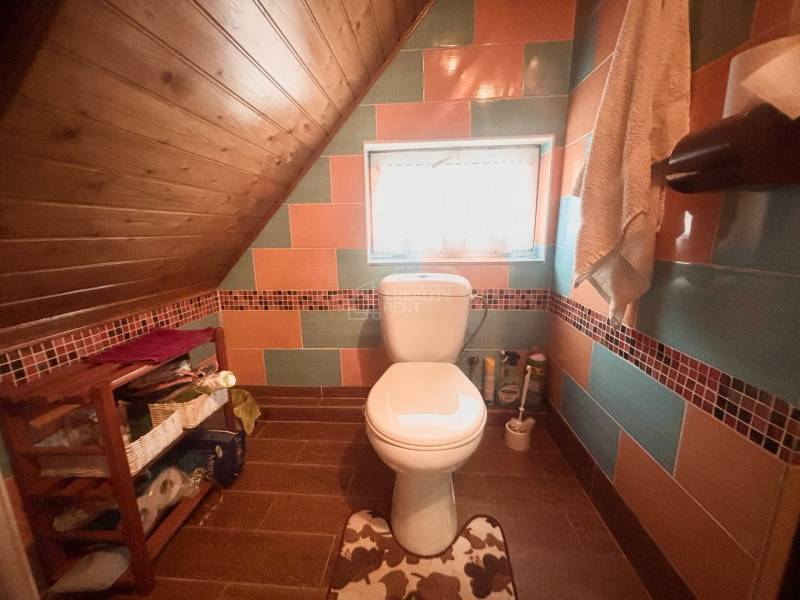 A bathroom in a family house with colorful tiles and a wooden floor decor.