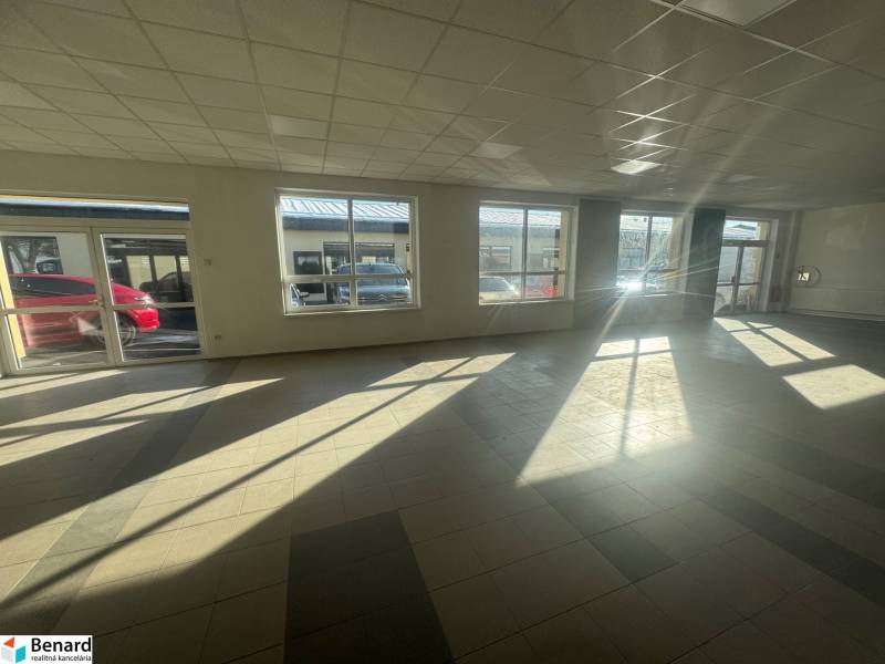 Spacious commercial spaces with large windows and tiling, illuminated by natural light.