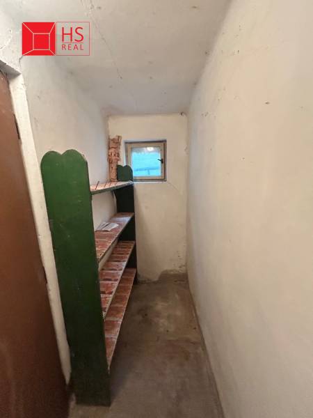 Compact hallway with shelves and a small window in a family house.