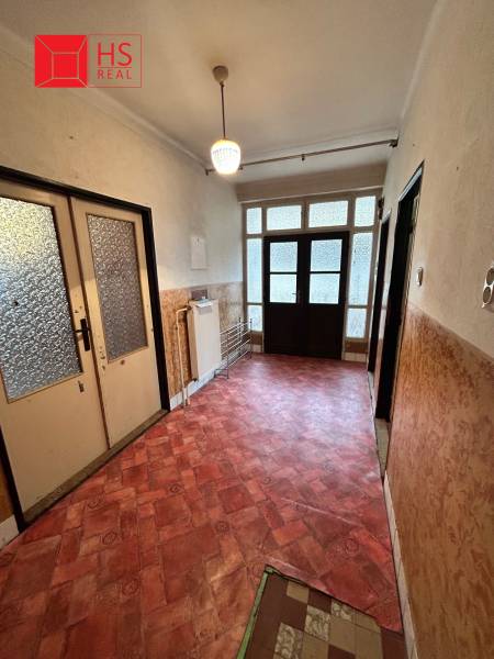 Hallway in a family house with a colorful floor and large glass doors.