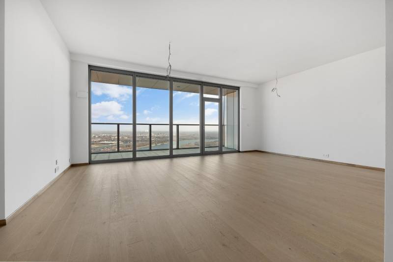 A spacious living room in a 3-room apartment with glass doors and a wooden decor floor.