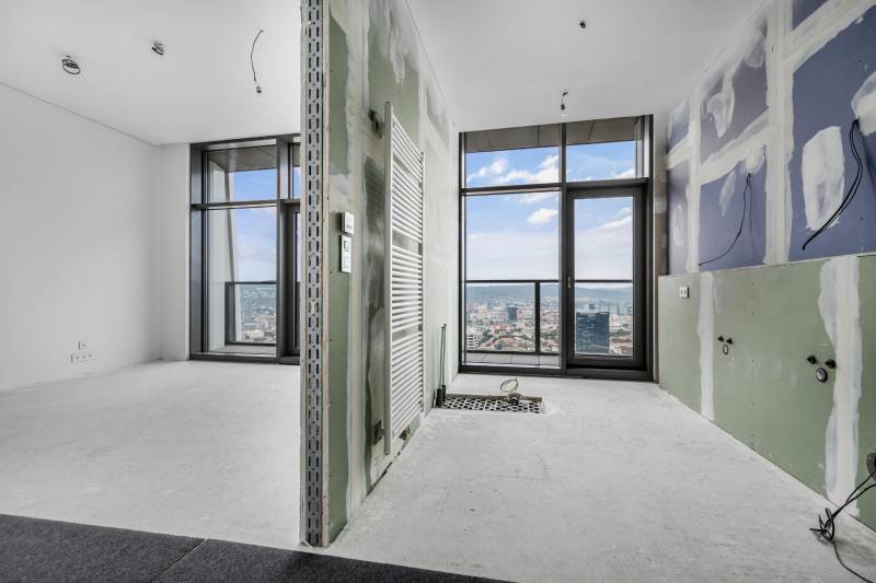 Unfinished interior of a 4-room apartment with large windows and a view of the city.