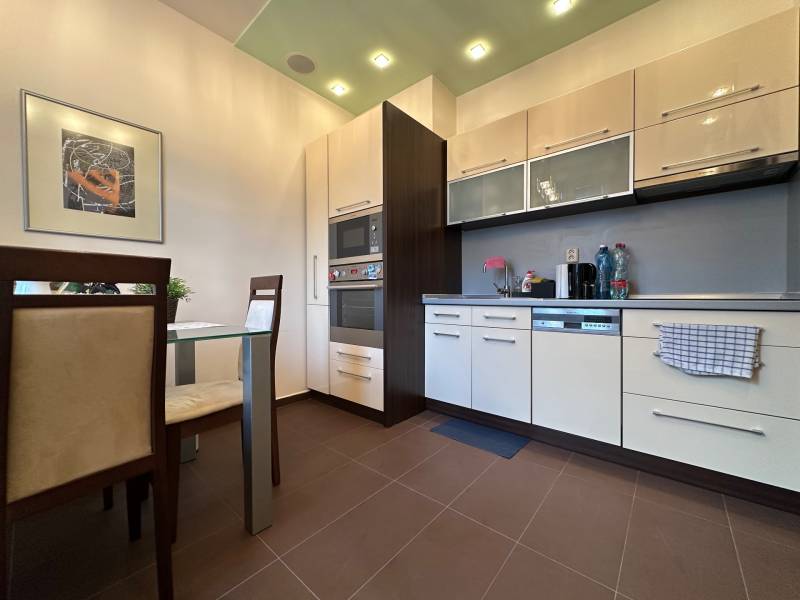 Kitchen in a 2-room apartment with a dining table and appliances.