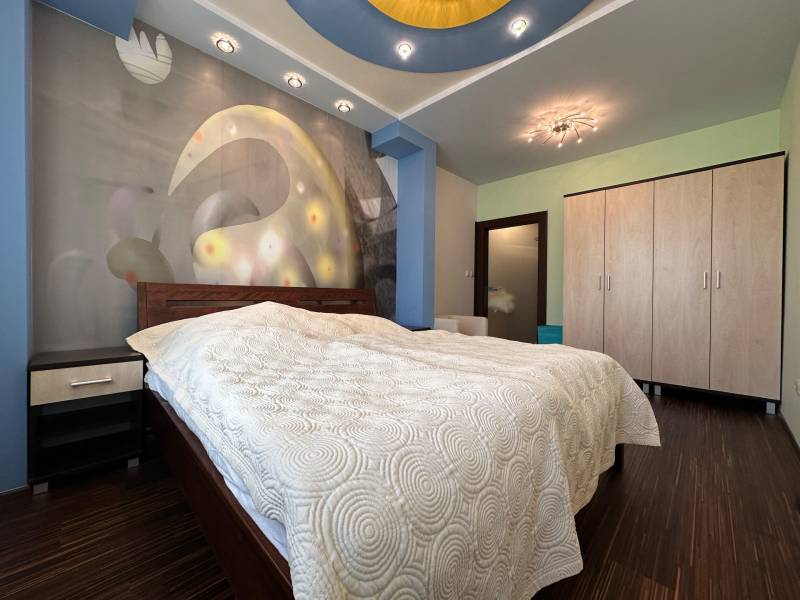 Bedroom in a 2-room apartment with a bed, cabinets, and a floor with a wood decor.