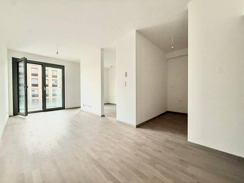 A bright living room in a two-room apartment with a wooden decor floor.