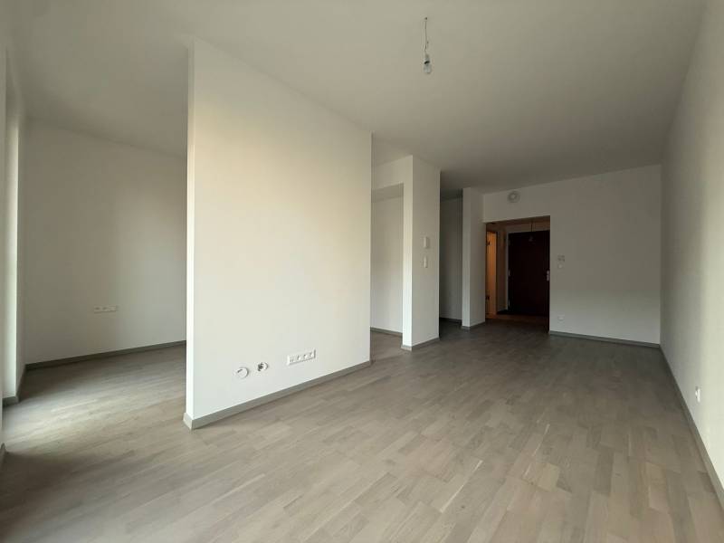 Interior of a 2-room apartment with a wooden decor floor and white walls.