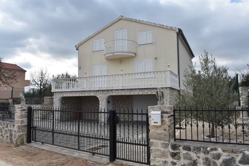 A family house in the town of Pridraga with a stone facade, garden, and balcony.