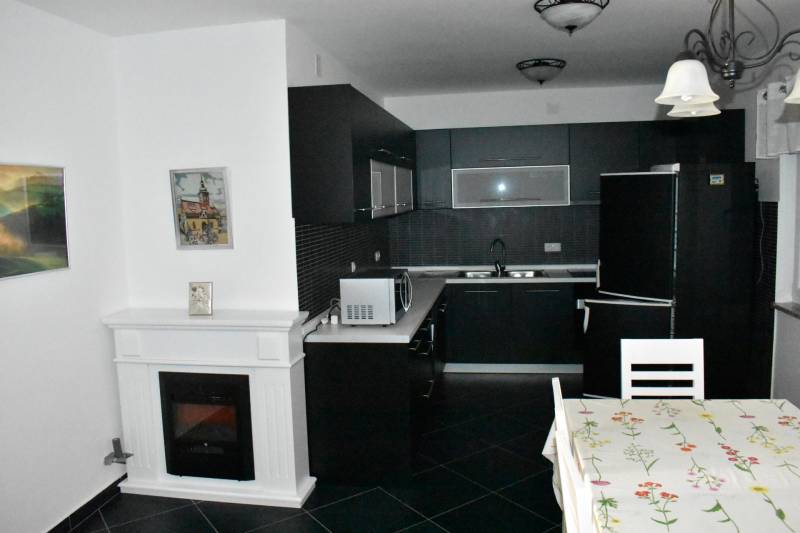 A kitchen in a family house with a black countertop and a dining table.