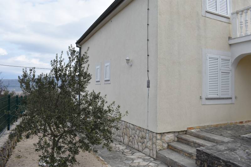 The exterior of a family house in Pridraga with a light facade and stone cladding.