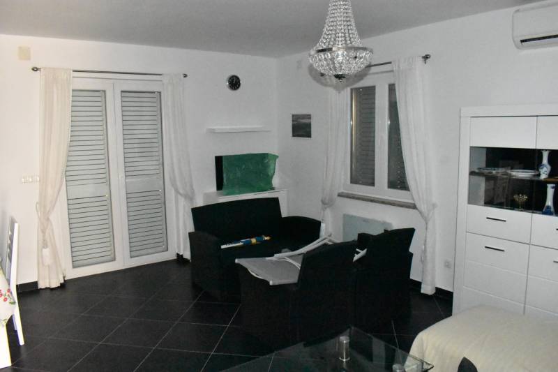 A living room of a family house with black furniture and a glass cabinet.