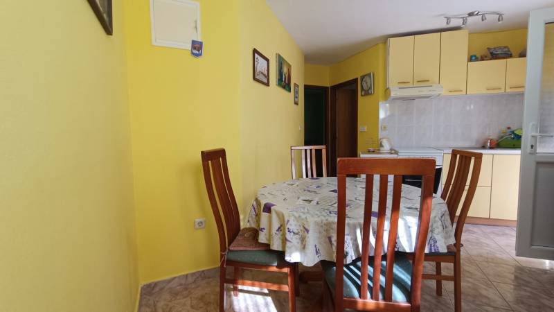 A kitchen in a family house with a dining table and yellow walls.