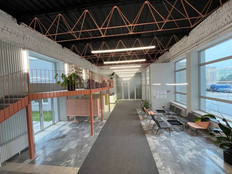 A spacious hallway with a metal gallery and upholstered seating, suitable for a studio apartment.