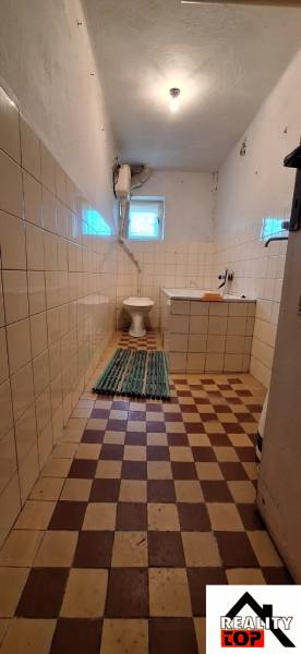 Bathroom in a family house with tiles and basic equipment.