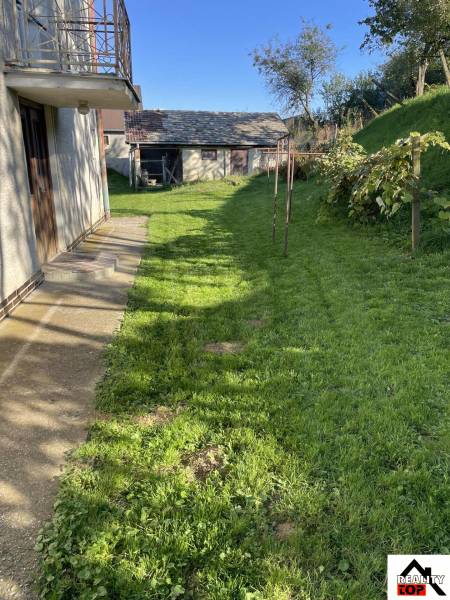 A family house in Hajnáčka with a lawn and a garden shed in the yard.