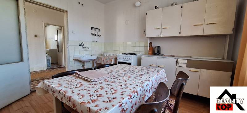 A kitchen in a family house with a dining table, a counter, and a stove.