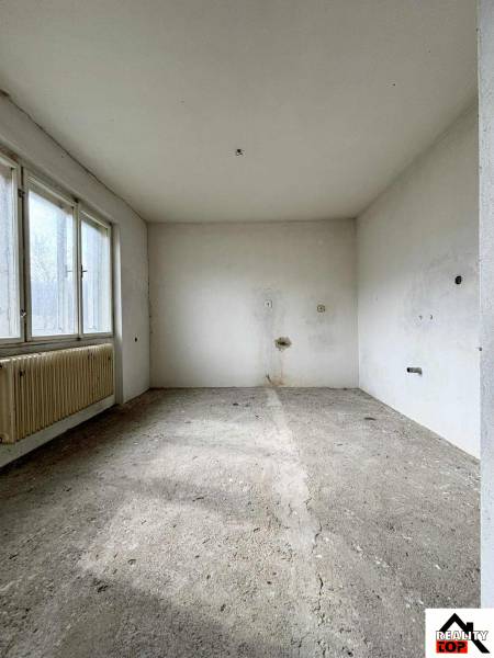 Empty room in a family house with a concrete floor and large windows.