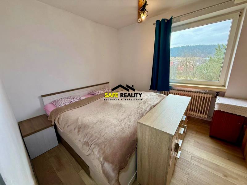 A bedroom in a family house with a bed and a wooden decor floor.