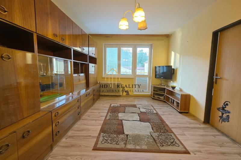 Living room in a three-room apartment with a wooden decor floor and furniture.