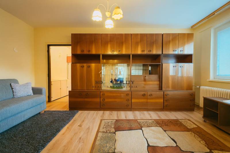 Living room in a 3-room apartment with a wooden decor floor and retro-style furniture.
