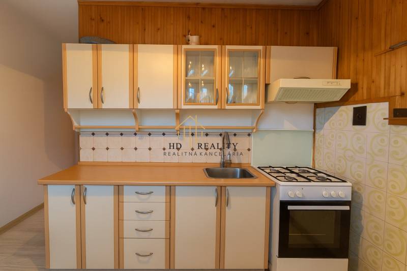 A kitchen in a 3-room apartment with a gas stove and wooden cabinets.