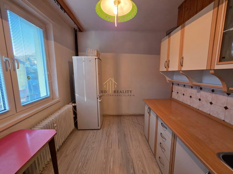 A kitchen with light furniture and floor decor, part of a 3-room apartment.