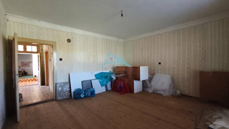 The interior of a family house with a wooden decor floor, an unused space full of tools.