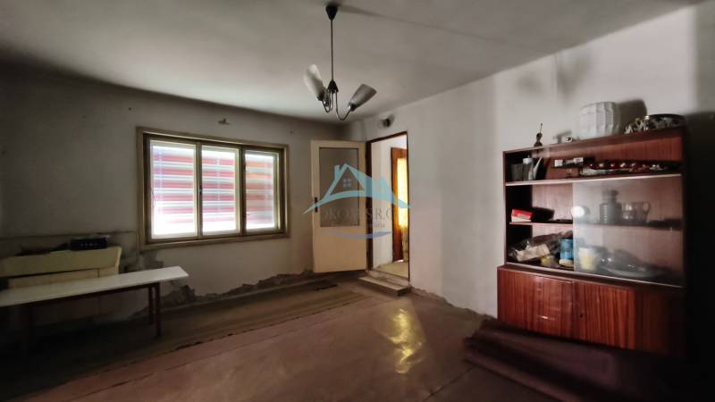 A room in a family house with simple furniture and a ceiling lamp.