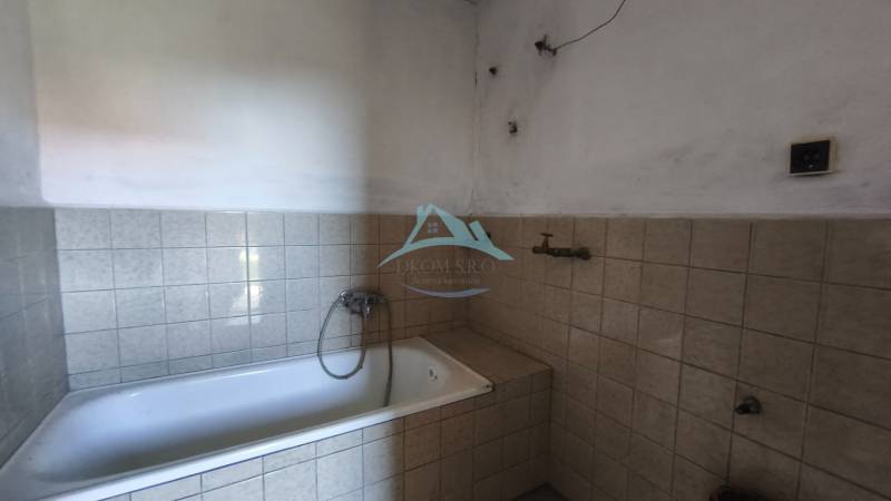 A bathroom in a family house with a bathtub tiled with light tiles.