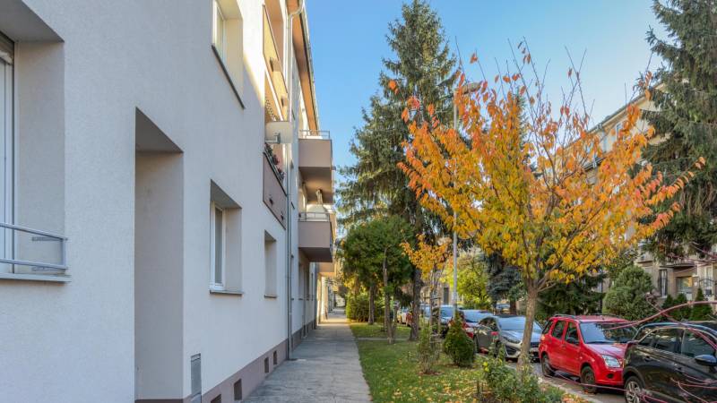 Pavlovova Street in Bratislava-Ružinov with autumn trees and parked cars near a 3-room apartment.