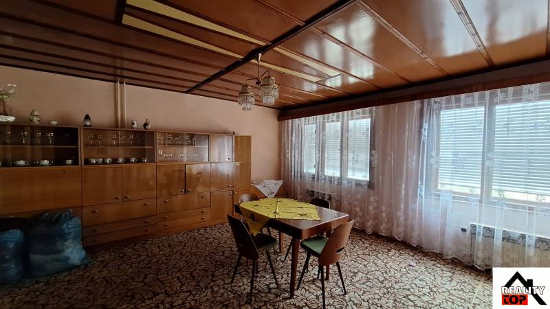 Living room in a family house with wooden decor and a large glass cabinet.