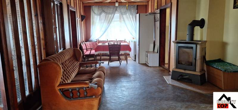 Living room in a family house with a sofa, stove, and round table.
