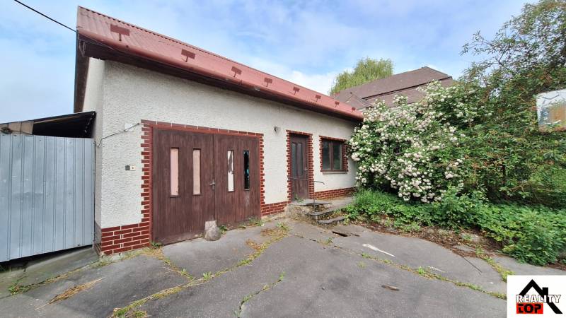 A family house in Nová Bašta with a wooden entrance and a flower garden.