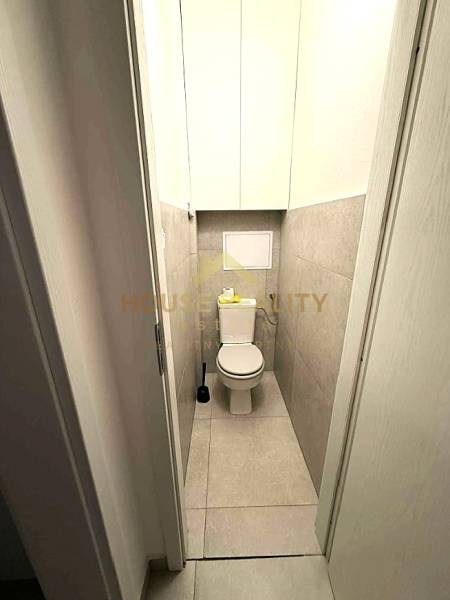 A bathroom with a toilet and tiles in a 4-room apartment.