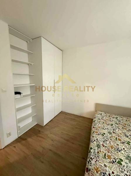 A room in a 4-room apartment with a wooden decor floor and a built-in wardrobe.