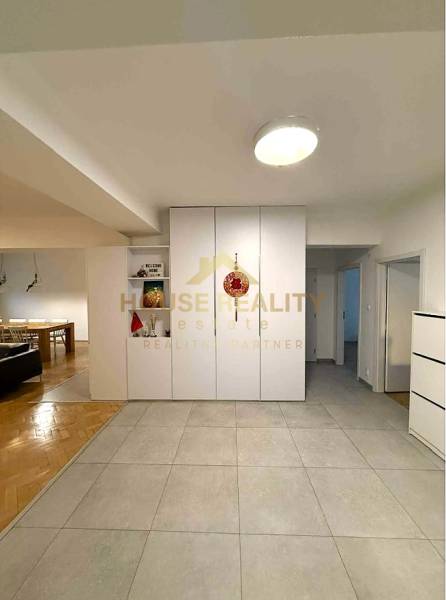 Interior of a 4-room apartment with tiles, seating area, and flooring with a wood decor.