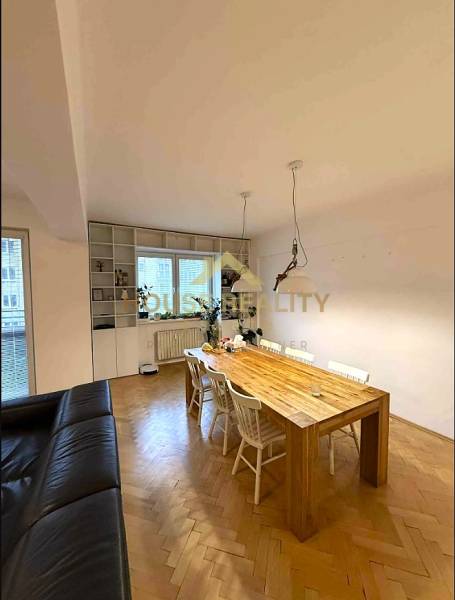 Dining table and chairs, large window, wooden decor flooring, 4-room apartment.